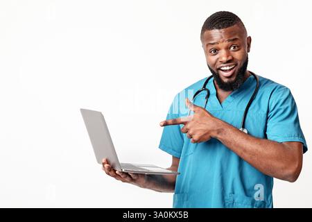 Emotional African American doctor holding laptop over white background Stock Photo