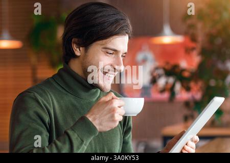 Happy businessman reading news while drinking morning coffee Stock Photo