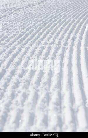 Curved lines in rough white snow surface texture abstract background Stock Photo