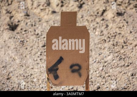 Bullet Riddled Target Cardboard silhouette target riddled with gunshot bullet holes, showing ...
