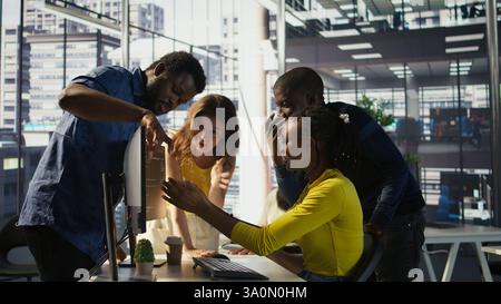 Upset IT workers in office debating, doing brainstorming, looking through lines of code on computer. Team of company employees discussing in workspace, disagreeing with each other, camera B Stock Photo
