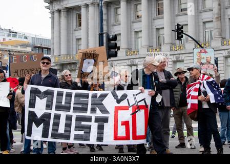 San Francisco, USA. 4th Mar 2025. Protesters gather in front of San Francisco City Hall to protest President Trump's executive orders and the actions of Elon Musk and his DOGE team, including the mass firings of federal workers. Two men hold a large banner reading, "Musk must go." Credit: Shelly Rivoli/Alamy Live News Stock Photo