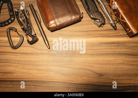 Black and leather EDC gear on a wooden background. Stock Photo