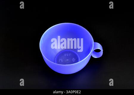Blue plastic cup on a black background. Stock Photo