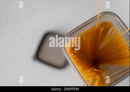 Overhead view of an open kitchen container full of spaghetti used for preparing Italian pasta dishes standing Stock Photo