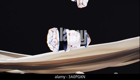 Image of ancient sculpture heads falling over beige fabric on black background Stock Photo