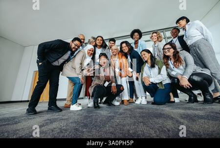 A diverse group of business professionals taking a happy selfie at a conference. Smiling and enjoying a moment of togetherness. Stock Photo