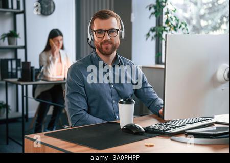 Woman is behind the man. Two employees are working together in the modern office. Stock Photo