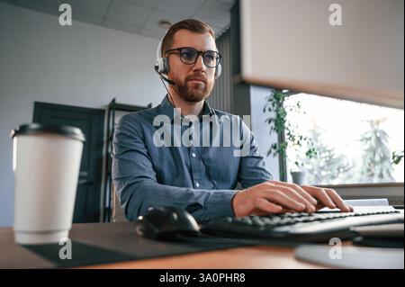 Typing on the keyboard. Man in formal clothes is working in the modern office. Using computer. Stock Photo