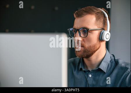 Portrait of man that is in formal clothes, working in the modern office. Using computer. Stock Photo