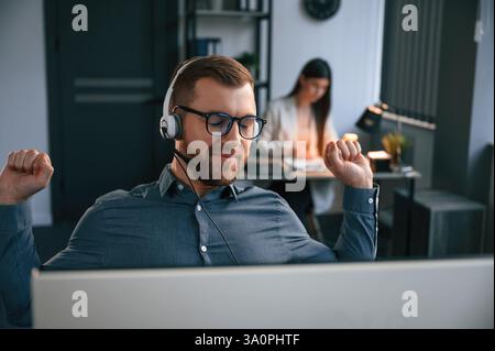 Woman is behind the man. Two employees are working together in the modern office. Stock Photo