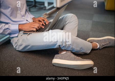 Unrecognizable male student freelancer using computer for working Stock Photo