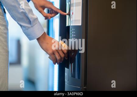 Unrecognizable young business man making coffee at coworking modern office Stock Photo