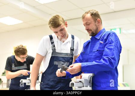 Group of young people in mechanical vocational training with teacher Stock Photo
