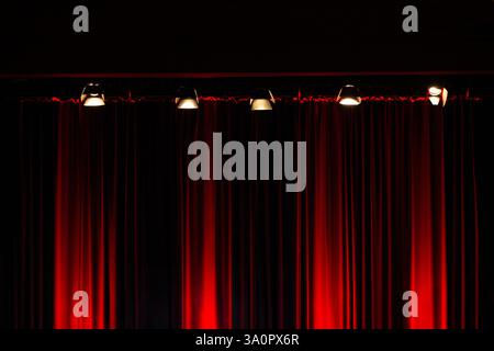 Stage lights on red velvet theater curtain Stock Photo