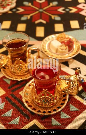 Cups of Hot Turkish Pomegranate and Apple Tea with a Plate of Assorted Turkish Delights Stock Photo