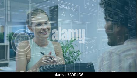 Smiling woman in office with data processing image over transparent screens Stock Photo