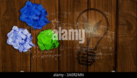 Image of mathematical equations over lightbulb and crumpled paper Stock Photo