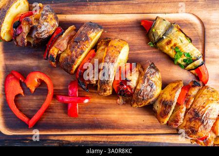 Colorful skewers of grilled vegetables and tender meat are beautifully arranged on a wooden serving board. Fresh ingredients highlight the vibrancy of Stock Photo