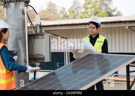 Inspecting solar panels for sustainable energy solutions. Engineers working on solar technology at an outdoor site. Stock Photo