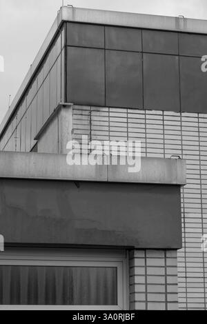 Modern building facade showcasing geometric shapes, textures, and various building materials in monochrome Stock Photo