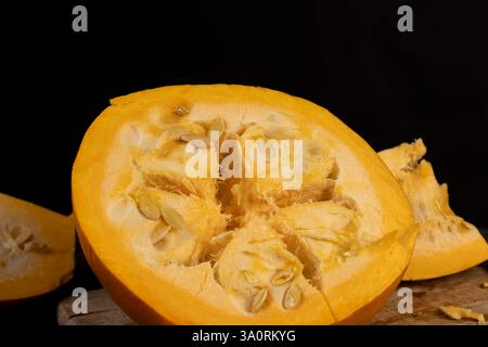 pumpkin with seeds cut into pieces close up, details of the pumpkin part with soft sweet flesh and large seeds Stock Photo