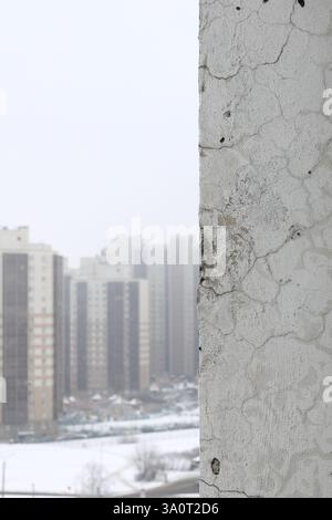 Abstract background vertical orientation with a defective wall and a heavily blurred background with multi-storey buildings on the left for text or in Stock Photo