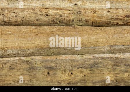 Horizontal arrangement of logs without bark, showcasing their natural wood texture and rustic appearance Stock Photo