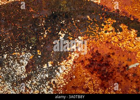Close-up of rusted metal and weathered paint, featuring corrosion, peeling layers, and rough textures, perfect for background and texture Stock Photo