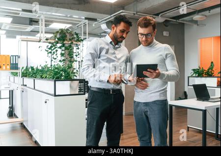 Two men are working in the modern office together. Stock Photo