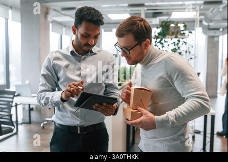 Two men are working in the modern office together. Stock Photo