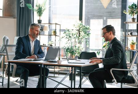 Two men is working on the project. Business people are together in the office. Stock Photo