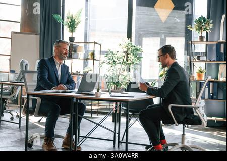 Two men is working on the project. Business people are together in the office. Stock Photo