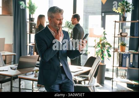 Three people are busy in the office. Group of employees are working together. Stock Photo