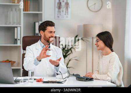 With woman. Doctor in formal clothes is working in the cabinet. Stock Photo