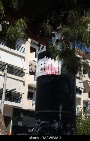 Abstract Face on Poster on Pine Tree  Glyfada Athens Attica Greece Stock Photo