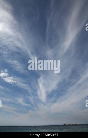 Wispy White Clouds in blue sky over Vouliagmeni Beach Athens Attica Greece Stock Photo