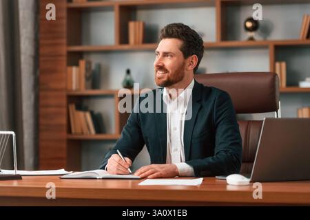Thinking, having an idea. Businessman in formal clothes is working indoors. Stock Photo