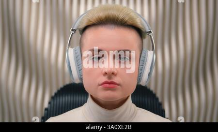 Calm serious woman Caucasian girl businesswoman female hipster gamer wearing wireless headphones modern futuristic innovative technology virtual Stock Photo