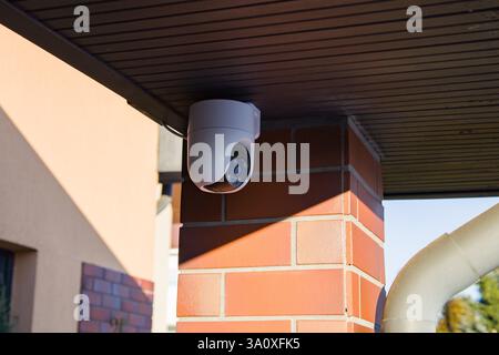 A view of an outdoor surveillance camera mounted on the wall of a private residential house Stock Photo