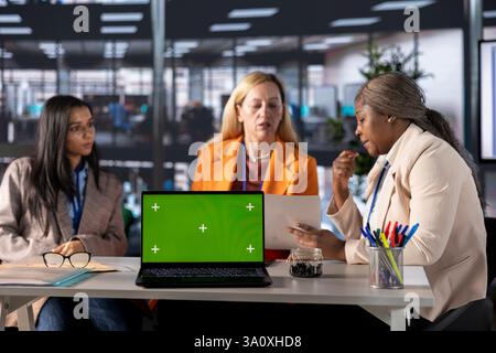 Group of multiethnic women working hard to prove themselves next to chroma key, fighting for success in a men dominated business industry. Diverse colleagues ensuring firm expansion. Stock Photo