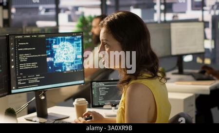 System administrator at work doing debugging of AI software using PC, checking glitches in lines of code. IT specialist in office fixing artificial intelligence coding issues using computer, camera A Stock Photo