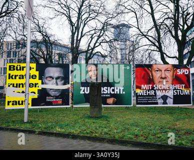 Freiburg, germany - Feb 10, 2025: Three political billboards during a Chancellor election in Germany feature stark, contrasting portraits of candidate Stock Photo