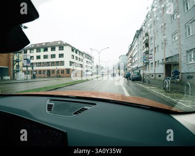 Frankfurt, Germany - Feb 10 2025: View from a car on a rainy day in Freiburg, Germany, showing wet streets and urban architecture. Stock Photo