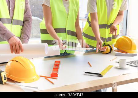 Team of constructors working at table in room Stock Photo