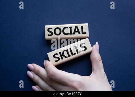 Social skills symbol. Wooden blocks with words Social skills Beautiful deep blue background. Businessman hand. Business and Social skills concept. Cop Stock Photo