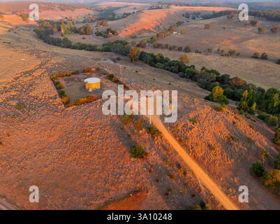 Aerial view of a dirt road leading to a lookout on the top of a dry barren hill at Guildford in Central Victoria, Australia. Stock Photo