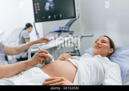 Close up view, scanning. Pregnant woman is lying down in the hospital, doctor does ultrasound. Stock Photo