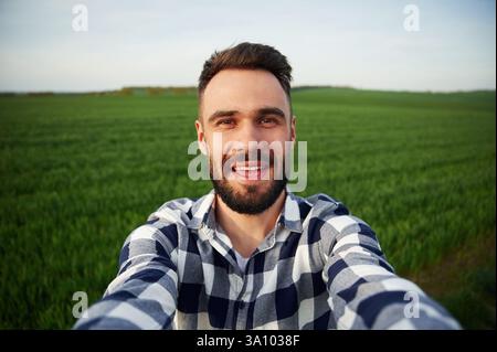 Making selfie. Handsome young man is on agricultural field. Stock Photo