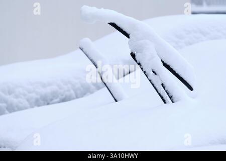 Close-up of windshield wipers of snow covered cars in winter. Seen in Germany in February. Stock Photo